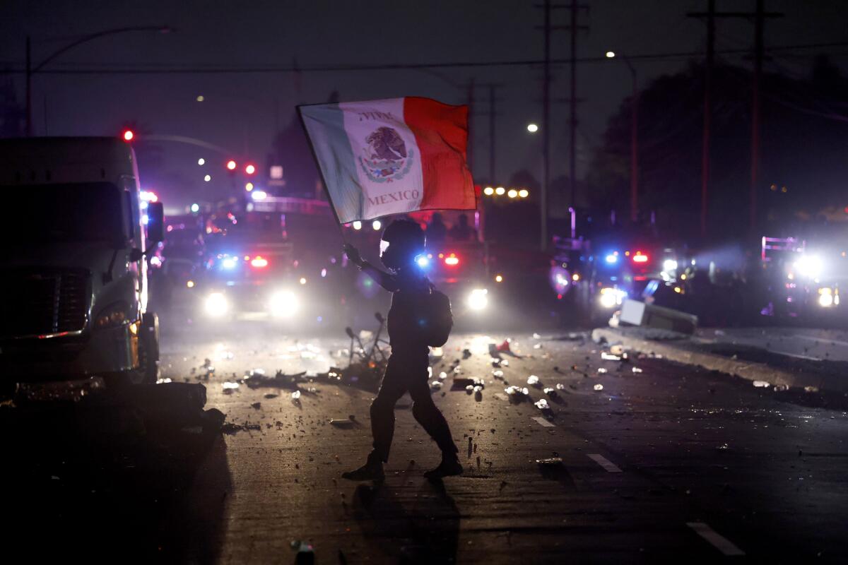 A protester carries the Mexican flag during a demonstration in Los Angeles.