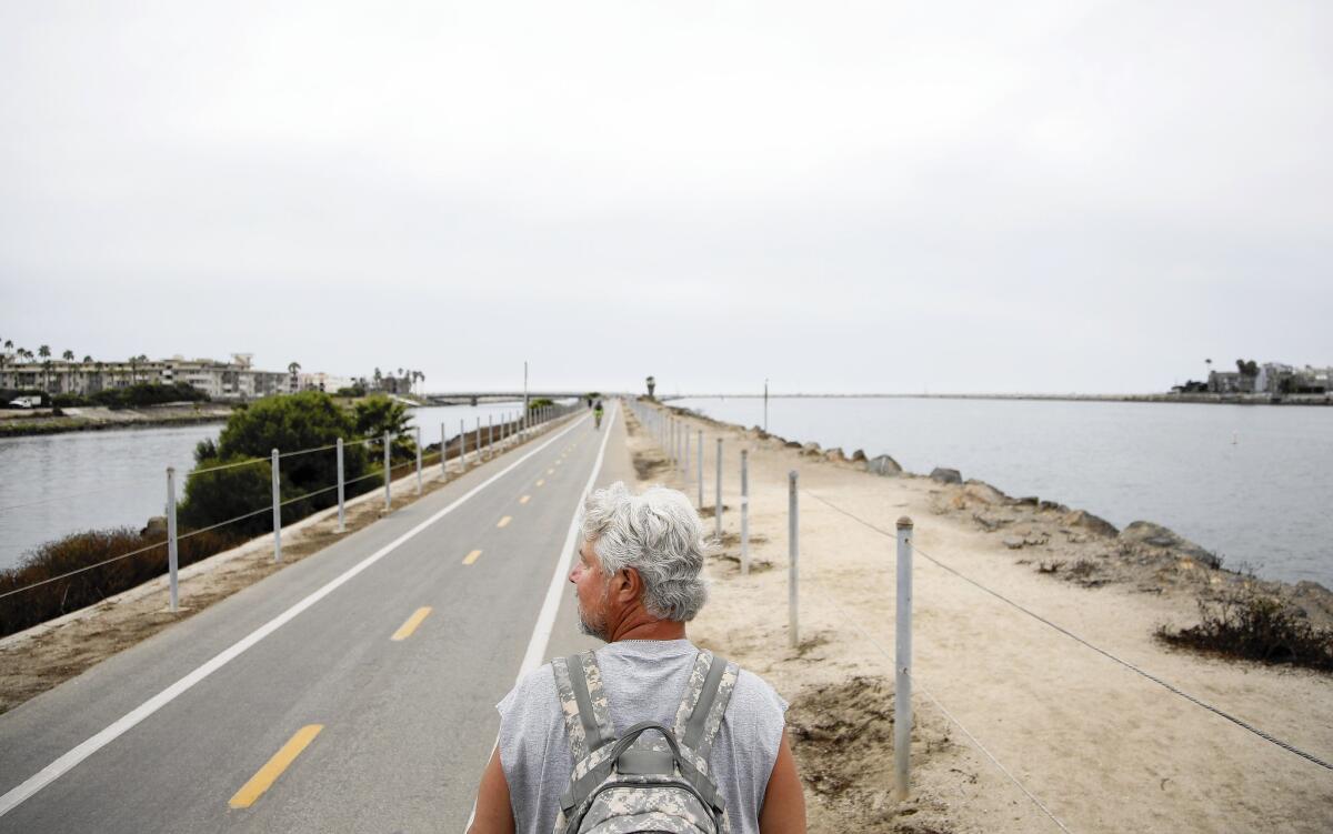 Dan Burchfield, a teacher at Moorpark High School, walks through Marina del Rey as part of his 130-mile journey to raise money for a scholarship fund in honor of his son Joel, who died in 1996 at the age of 11.