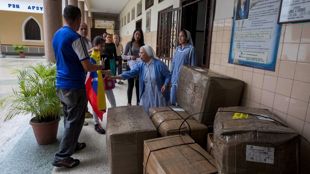Food and clothing sent by Tere Caicedo in Los Angeles is delivered to Sister Ana Medina Suarez, second from right, director of a retirement home for low-income men in Caracas, Venezuela.