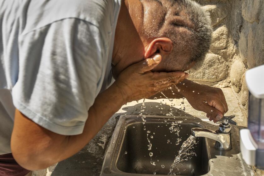 VAN NUYS, CA -SEPTEMBER 7, 2022: Hector Montero, 55, cools off after washing his ice cream truck at Lake Balboa Park in Van Nuys. A heat wave that has shattered temperature records nearly broke California's overtaxed electric grid, pushing it to the brink of rolling blackouts but narrowly averting widespread power loss. (Mel Melcon / Los Angeles Times)