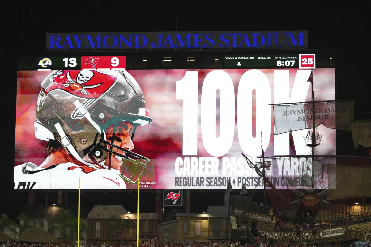 The Buccaneers scoreboard shows Tom Brady (12) has become the first NFL player to throw for 100,000 yards.