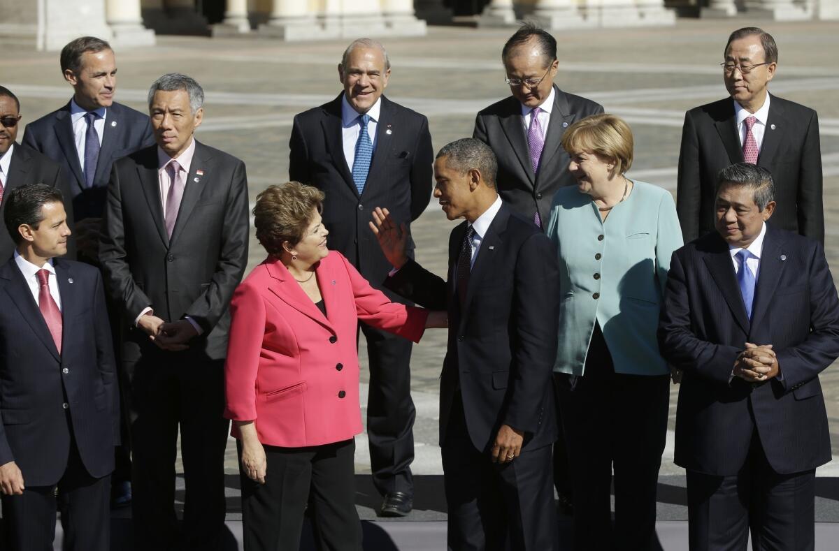 Brazilian President Dilma Rousseff and President Barack Obama greet each other as they join other world leaders for the group photo at the G-20 summit at Konstantin Palace in St. Petersburg, Russia.