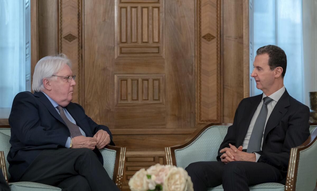 Martin Griffiths, left, meets with Bashar Assad, both seated