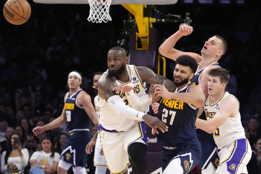 Los Angeles Lakers forward LeBron James, second from left, goes after a loose ball along with Denver Nuggets guard Jamal Murray, center, center Nikola Jokic, second from right, and guard Austin Reaves, right, after James knocked the ball from the hands of Jokic during the second half in Game 4 of an NBA basketball first-round playoff series Saturday, April 27, 2024, in Los Angeles. (AP Photo/Mark J. Terrill)