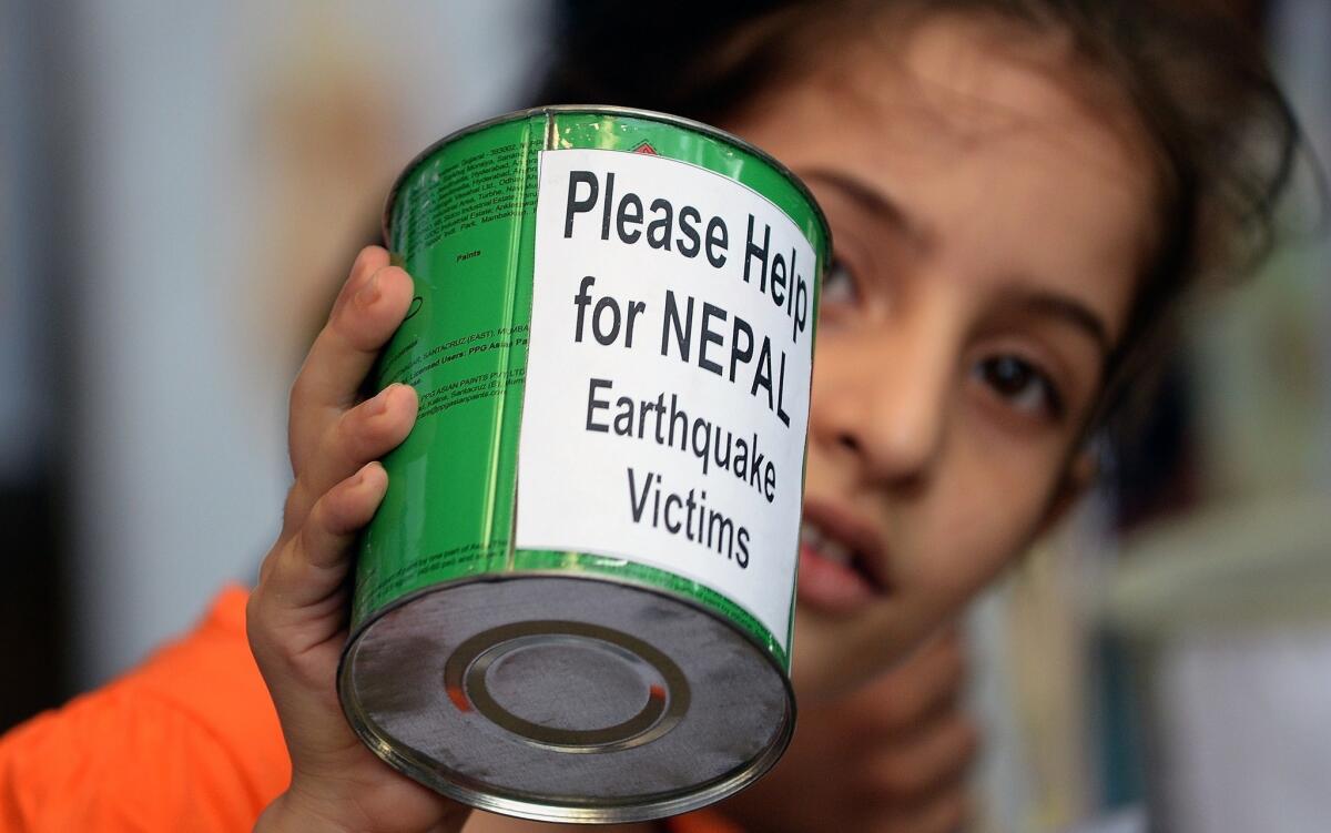 A school child in Mumbai, India, collects funds for victims of the devastating earthquake in Nepal.