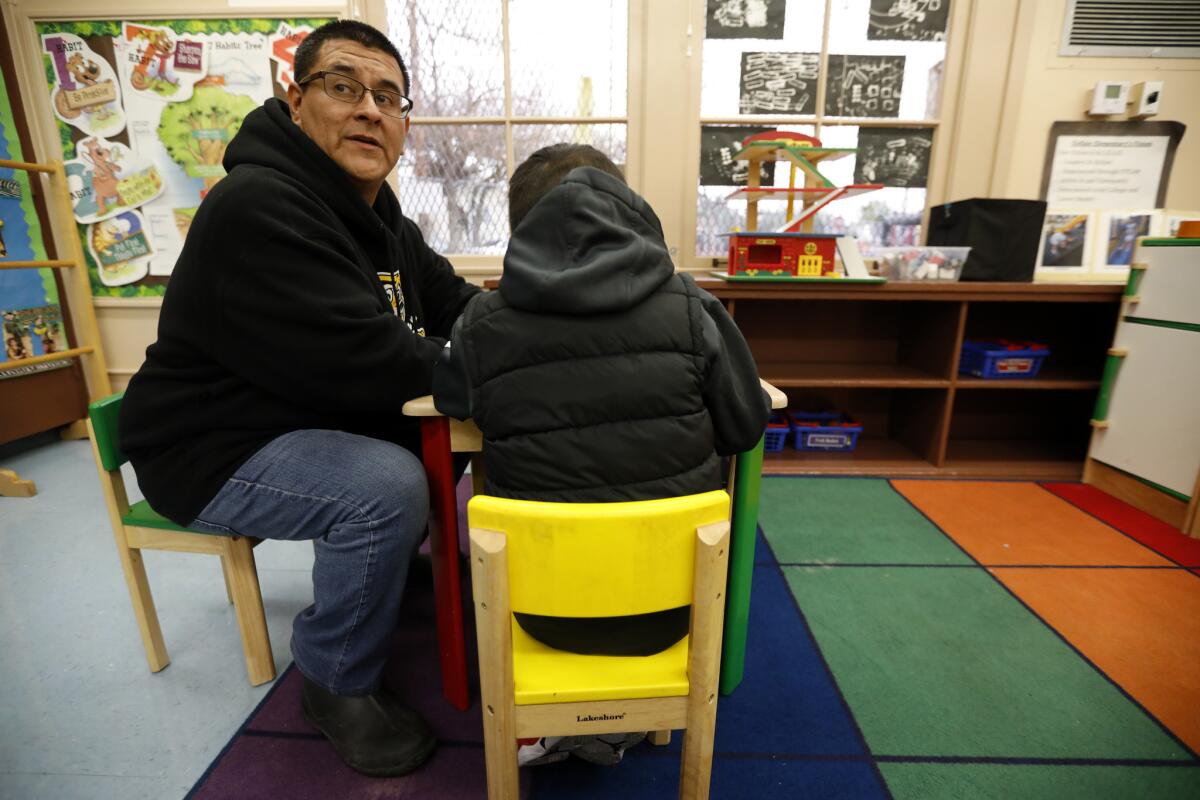 Principal Jose Razo works with a student at Telfair Elementary School in Pacoima.