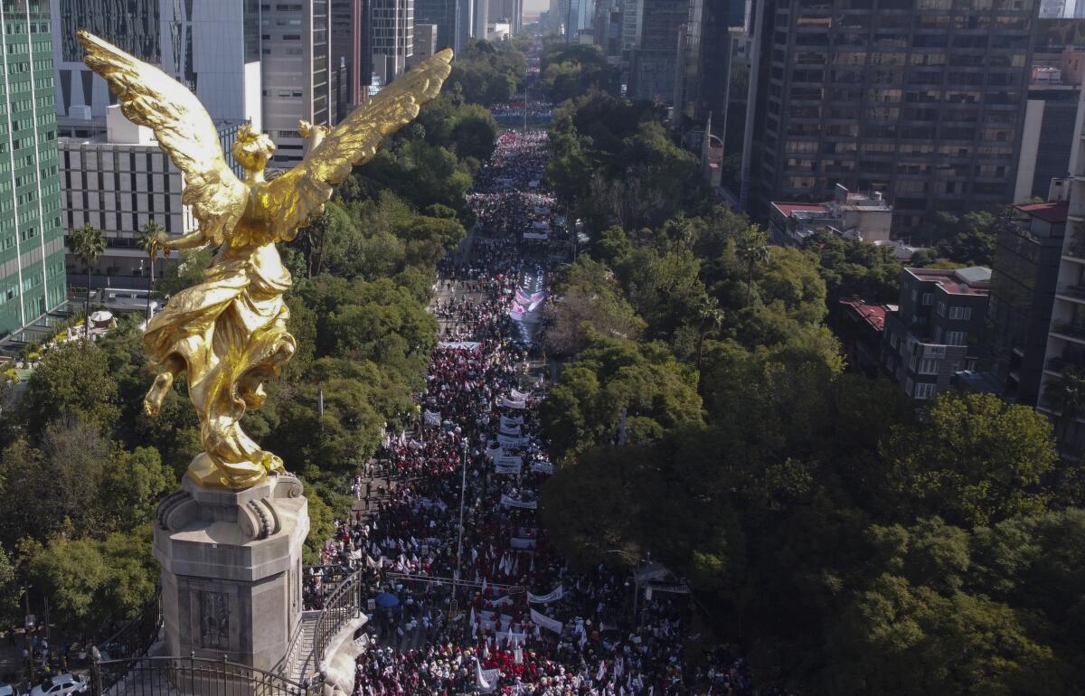 Supporters of Mexican President Andrés Manuel López Obrador fill a wide street.
