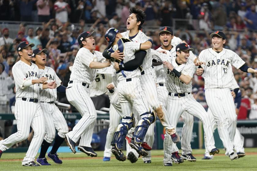Shohei Ohtani (16) celebrates with his teammates after Japan defeated the U.S. in the WBC 