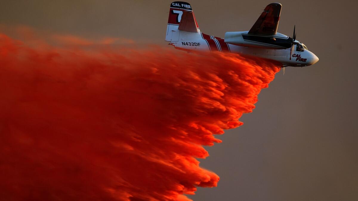 A Cal Fire S-2 air tanker disgorges a retardant slurry in 2014.