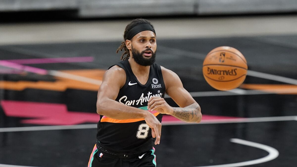 Patty Mills makes a pass while playing for the Spurs last season.
