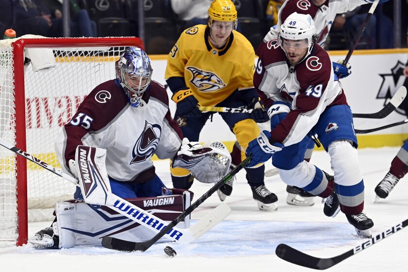 Colorado Avalanche defenseman Samuel Girard (49) moves the puck away from goaltender Darcy Kuemper (35) during the second period of an NHL hockey game Tuesday, Jan. 11, 2022, in Nashville, Tenn. (AP Photo/Mark Zaleski)