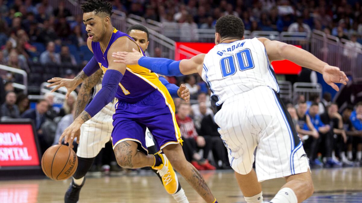 Lakers guard D'Angelo Russell drives past Magic forward Aaron Gordon (00) and guard D.J. Augustin during the first half Friday night.