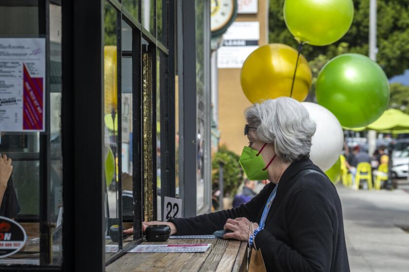 LARCHMONT VILLAGE, CA - MARCH 04: Wearing a mask outside Lynda Mitz places an outdoor Friday, March 4, 2022 in Larchmont Village, neighborhood of Los Angeles CA. Indoor mask wearing will no longer be mandatory in Los Angeles County starting today. (Francine Orr / Los Angeles Times)