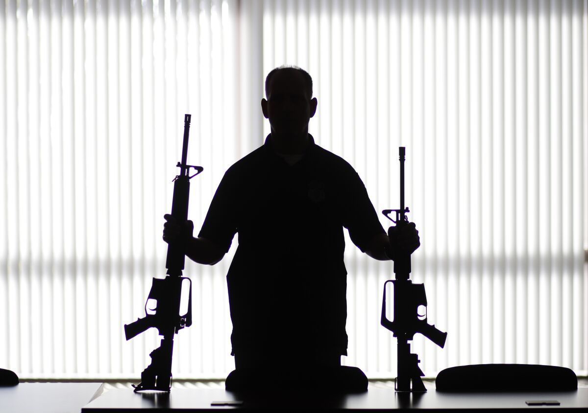 Silhouette of a man holding two long guns
