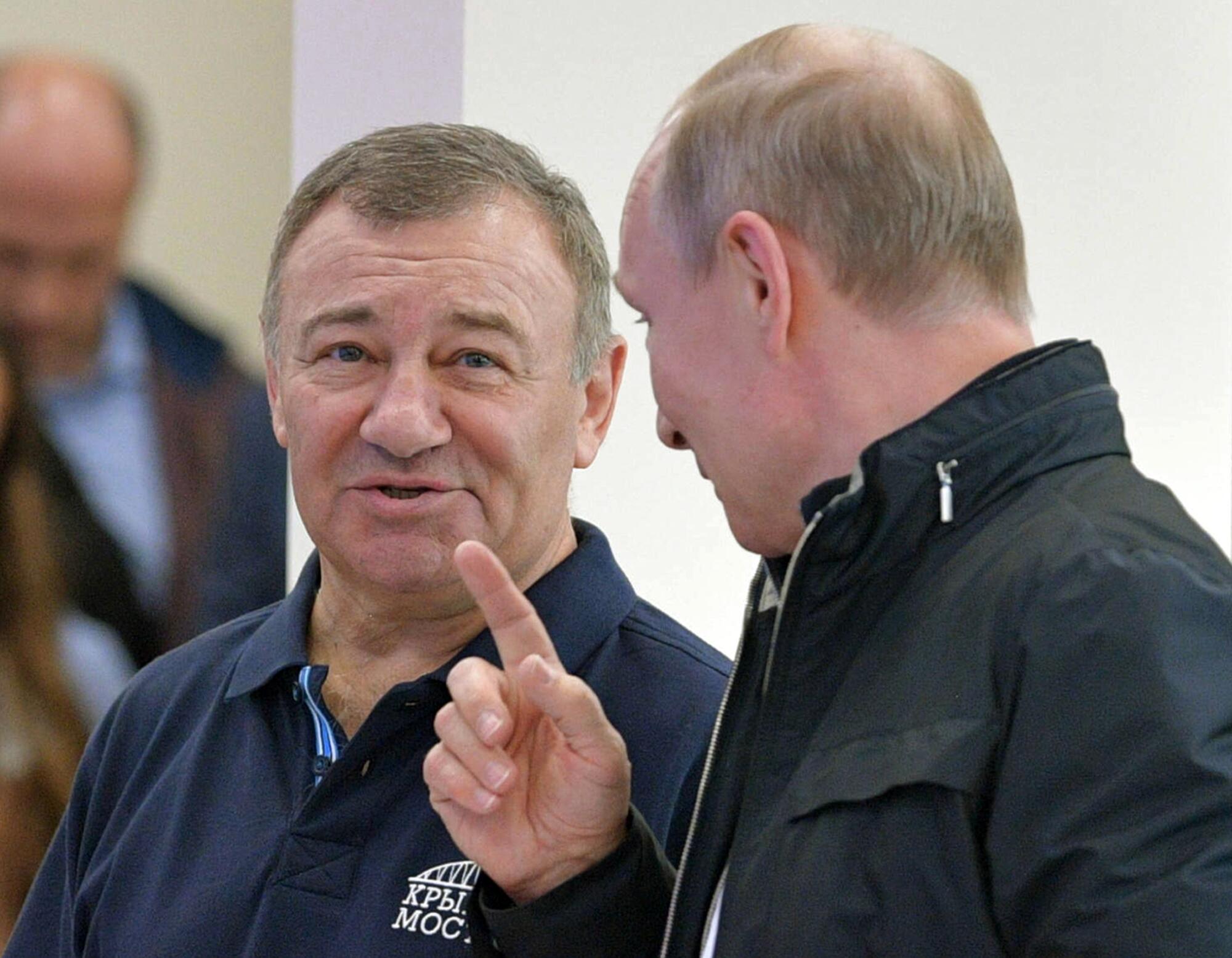 Russian President Vladimir Putin, right, gestures while speaking to Arkady Rotenberg