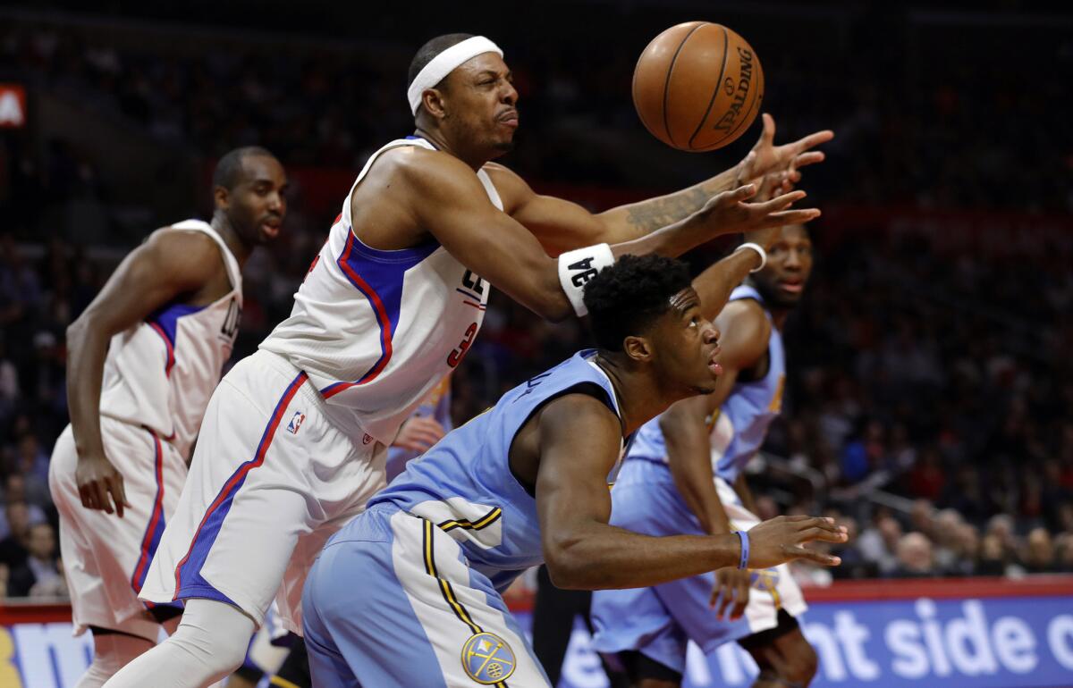 Clippers forward Paul Pierce, center, loses the ball to Denver Nuggets guard Emmanuel Mudiay, right, during first quarter action at Staples Center on Wednesday.
