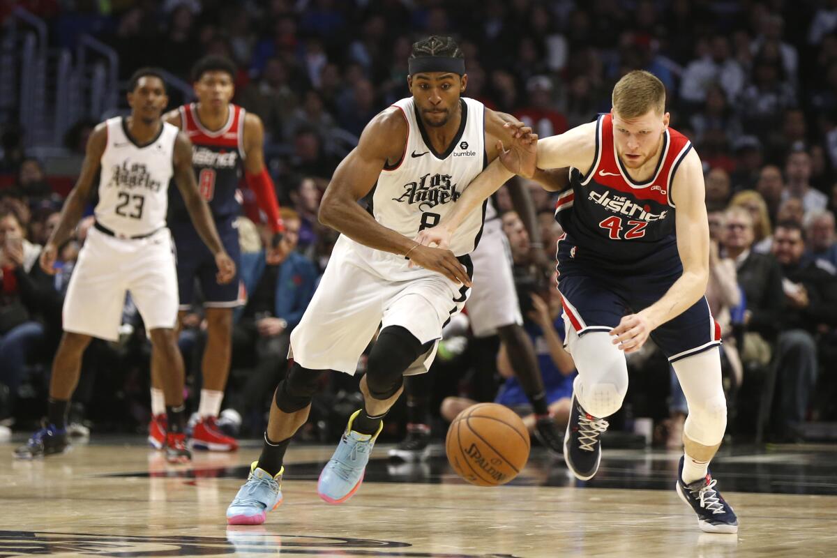 Clippers forward Maurice Harkless, left, battles Washington Wizards forward Davis Bertans for control of the ball.