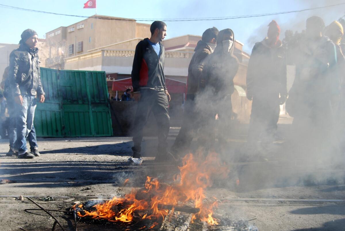 Tunisian youths in the central town of Kasserine burn debris as they protest against the Islamist party Ennahda and against the country's persistent economic crisis.
