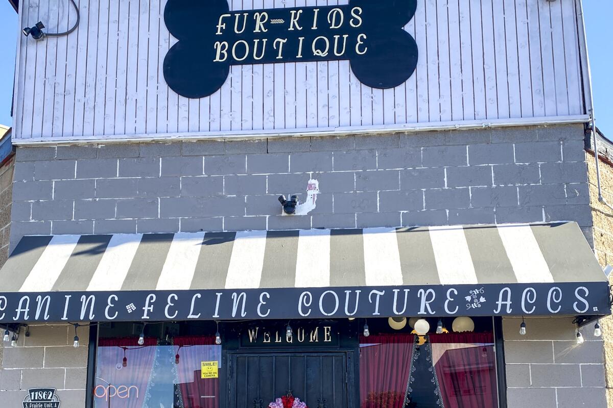 The exterior of Fur-Kids Boutique with an awning and bone-shaped sign.