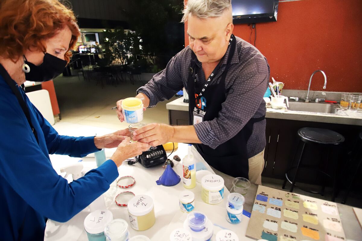 Artist and event organizer Mike Tauber helps artists choose paint colors at the Platter Painting Party.