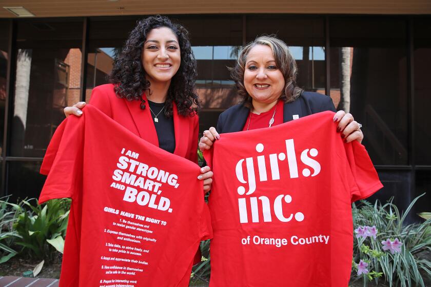 Emily Olvera, Girls Inc. and CEO Lucy Santana hold up red Girls Inc. of O.C. T-shirts.