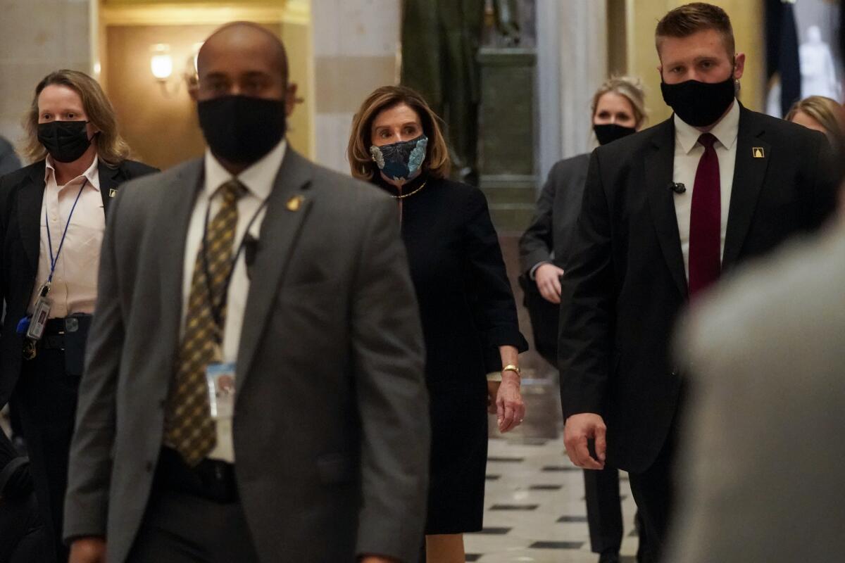House Speaker Nancy Pelosi, center, walks inside the Capitol before lawmakers vote to impeach President Trump on Jan. 12. 