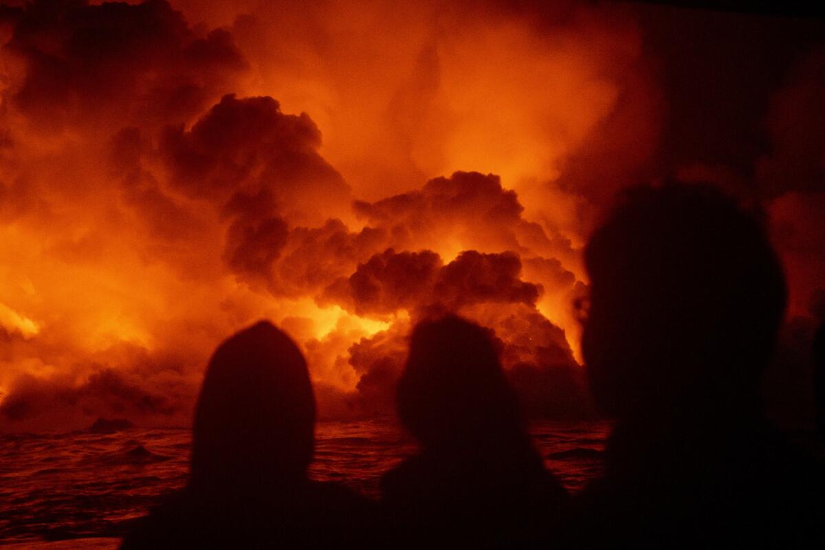 Passengers aboard the Lava Ocean Tour boat Hot Shot watch as lava hitting the ocean creates white acidic plumes known as "laze" — haze produced by lava.