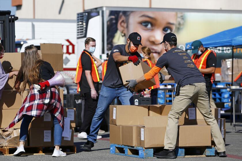 Employees unload boxes of frozen food on Thursday at Second HarvestOs distribution facility in Irvine as they prepare to for the 34th Annual Thanksgiving Day Event to provide Thanksgiving meals and supplemental groceries for Orange County residents who continue to struggle with food insecurity.