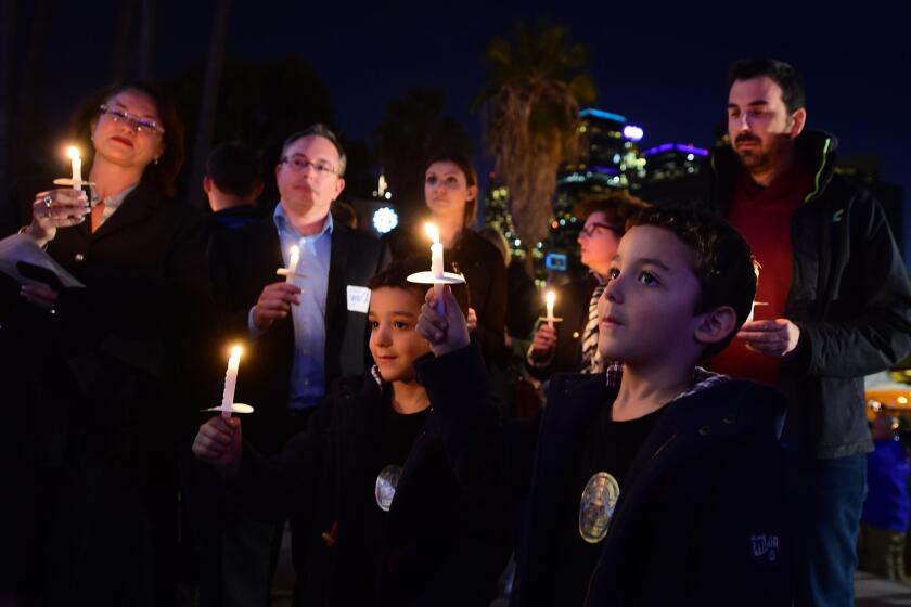 A crowd gathered outside Los Angeles City Hall Tuesday night to remember the victims of the recent attacks that devastated Paris.