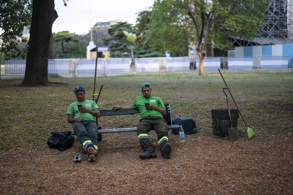 Limpiadores de calles toman un descanso en una plaza de la Ciudad de Buenos Aires, Argentina,