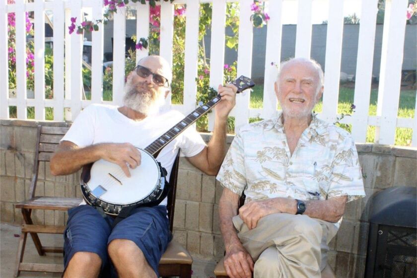 Musician and songwriter Chris Ryan, playing a five-string banjo, with his father, Roger Ryan.