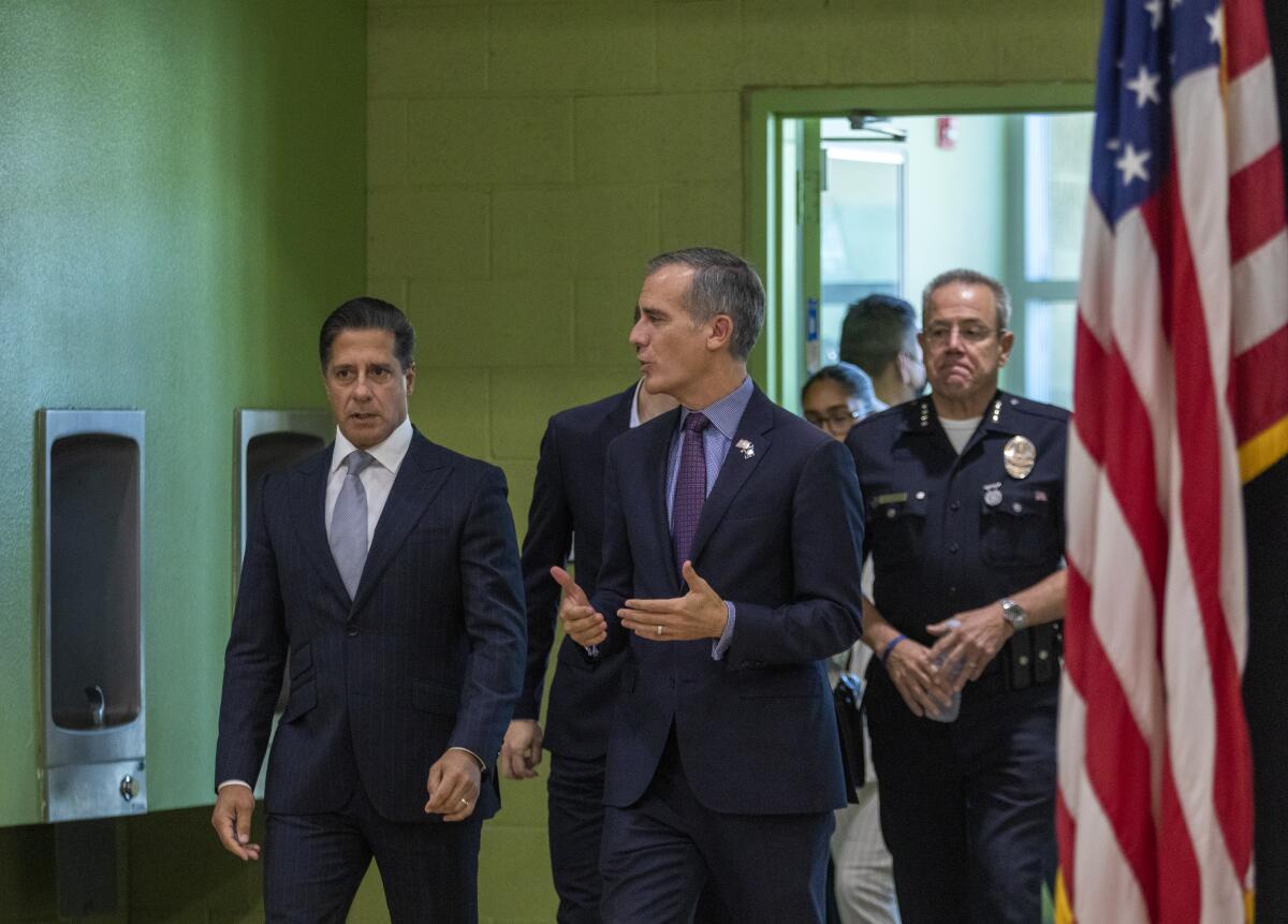 People in suits and one in a police uniform walking.