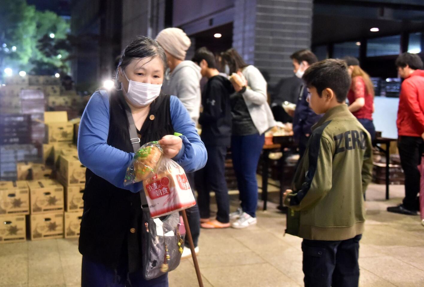 Evacuees line up for food supplies April 16 at Kumamoto City Hall.