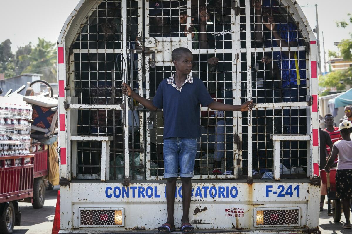 A boy standing on the back of a truck