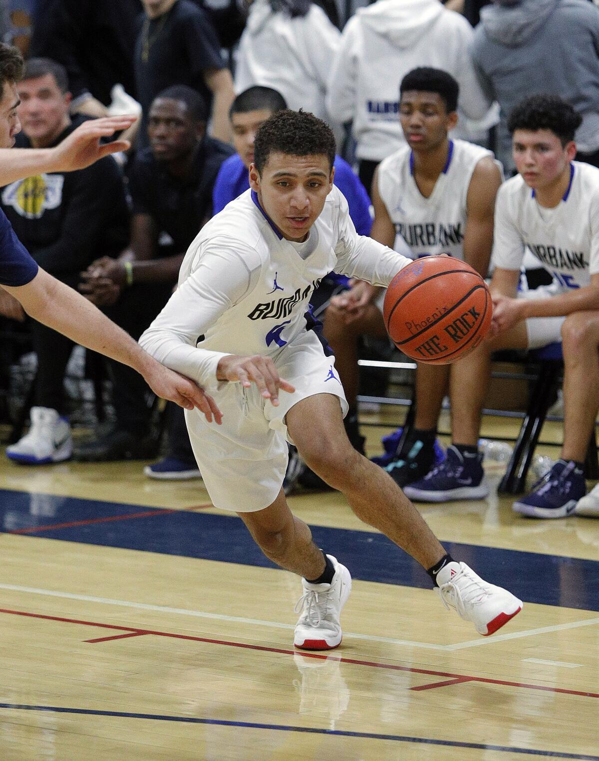 Burbank's Phoenix Mosley starts a drive outside the three-point line against Crescenta Valley in a Pacific League boys' basketball game at Burbank High School on Thursday, December 19, 2019.