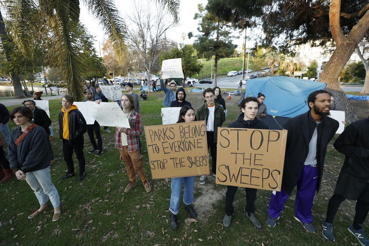 Activists and residents march through the Echo Park Lake tent encampment