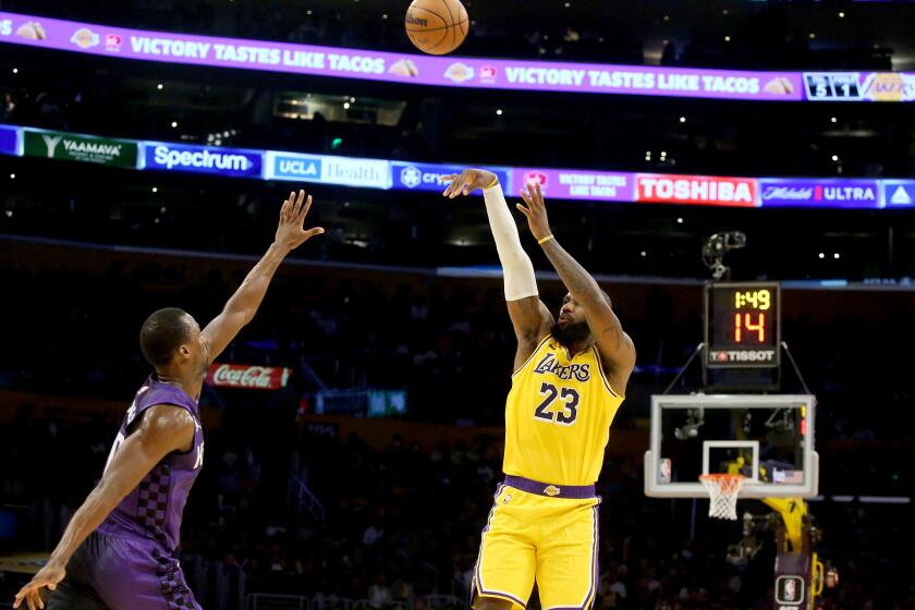 Los Angeles, CA - Lakers forward LeBron James shoots and scores a three-pointer against Kings defender Harrison Barnes in the first half at crypto.com Arena in Los Angeles on Wednesday night, Nov. 15, 2023. (Luis Sinco / Los Angeles Times)