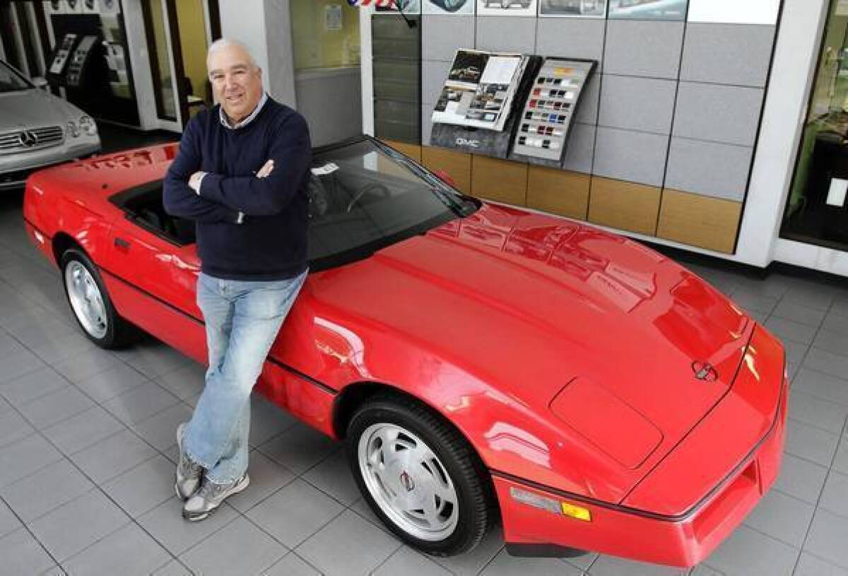 Corky Rice is shown with the Corvette that was parked in a storage locker since it was stolen in 1989.