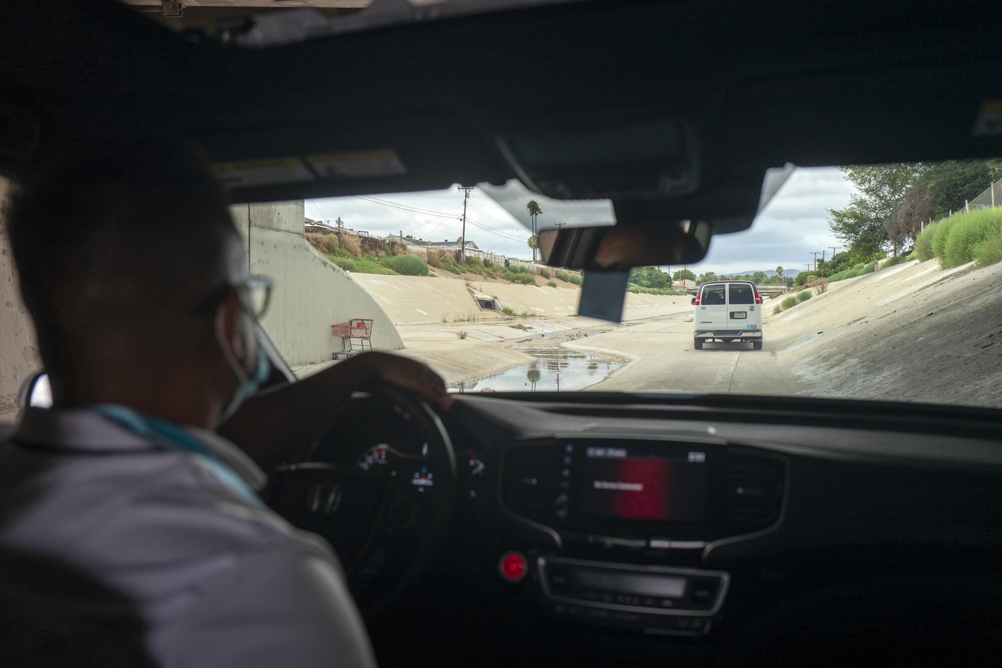 Dr. Absalon Galat behind the wheel of a county Department of Health Services van.