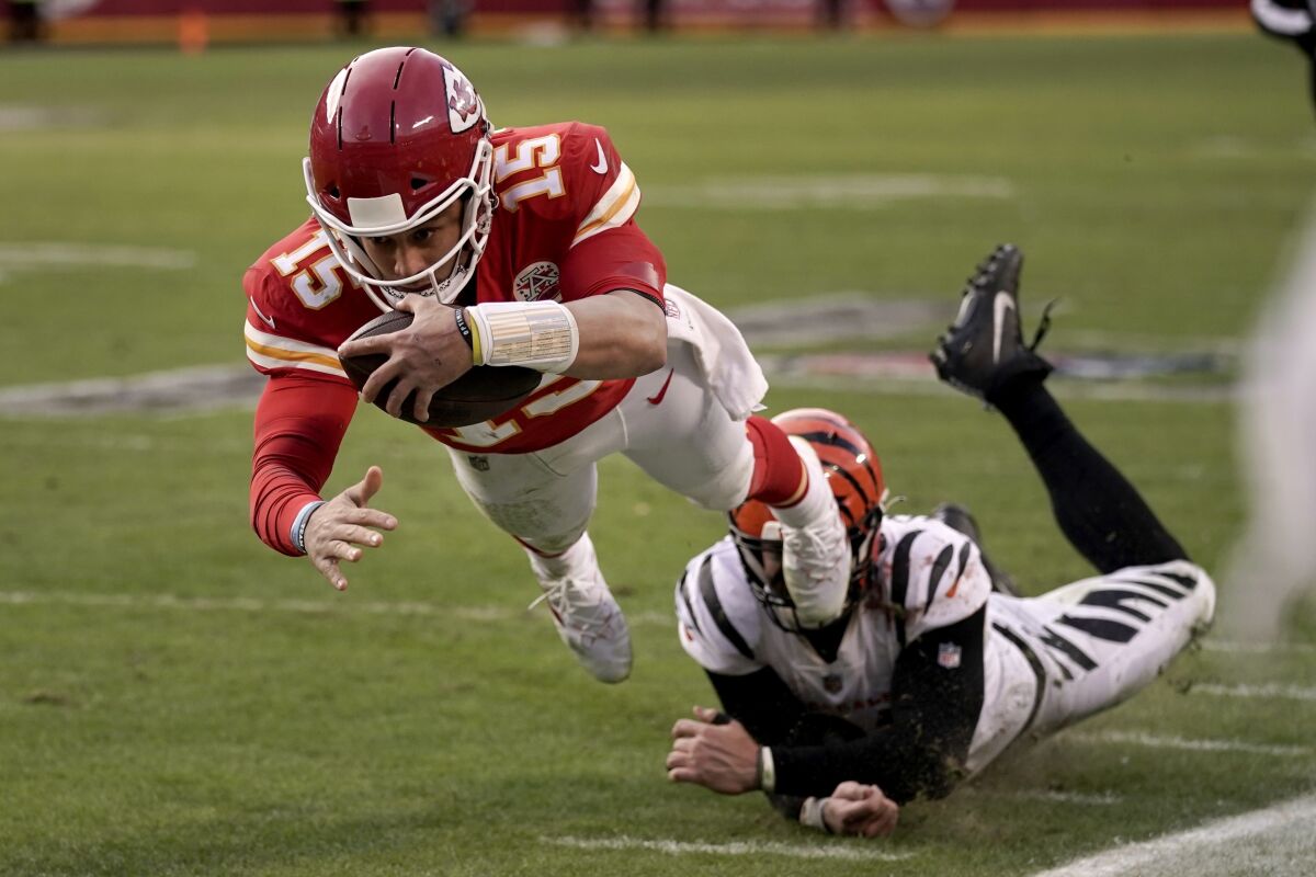Chiefs quarterback Patrick Mahomes dives after running the ball ahead of Bengals defensive end Trey Hendrickson.