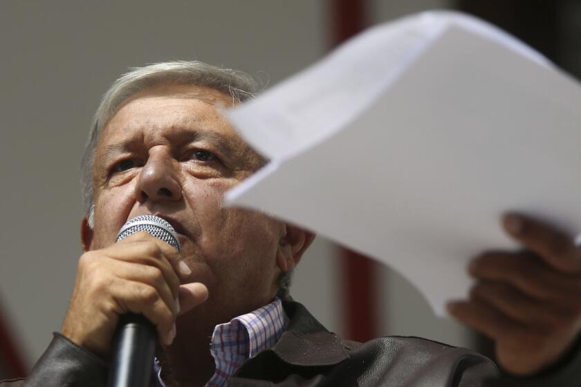 Mexico's President-elect Andres Manuel Lopez Obrador holds documents outlining the presidential salary as he speaks to reporters from his party's headquarters in Mexico City, Sunday, July 15, 2018. Lopez Obrador says he plans to earn 40 percent of what his predecessor makes when he takes office in December as part of an austerity push in government. (AP Photo/Anthony Vazquez)