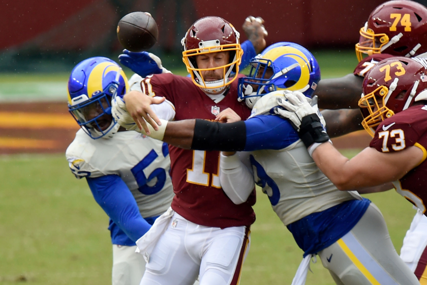 LANDOVER, MD - OCTOBER 11: Alex Smith #11 of the Washington Football Team is hit by Aaron Donald.