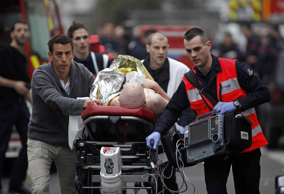 An injured person is evacuated outside the French satirical newspaper Charlie Hebdo's office, in Paris on Jan. 7, 2015. 