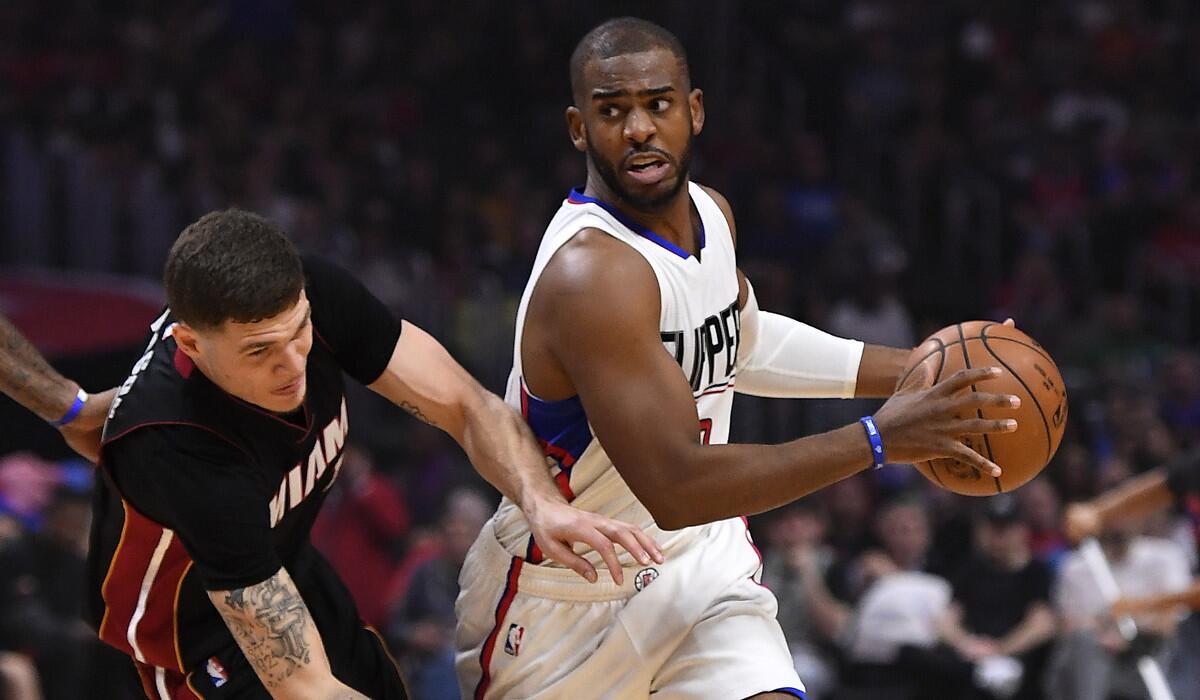 Clippers guard Chris Paul, right, drives past Miami Heat guard Tyler Johnson on Sunday at Staples Center.