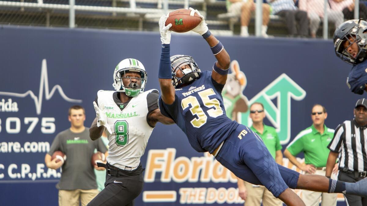 Florida International cornerback Rishard Dames (35) intercepts the pass intended for Marshall wide receiver Tyre Brady (8) during the second quarter on Nov. 24, 2018.