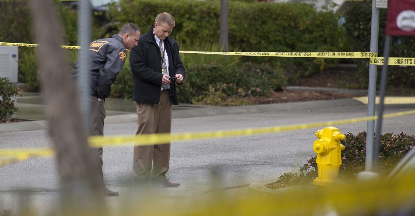 Orange County Sheriff's Department investigators examine the scene of an early morning shooting at 5 Red Leaf Lane that left a woman dead.