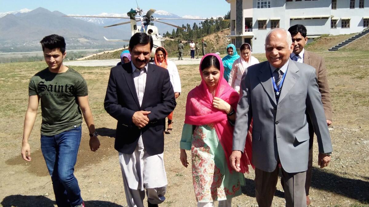 Nobel Peace Prize laureate Malala Yousafzai, now 20, arrives along with her brother Atal Yousafzai, from left, father Ziauddin Yousafzai, and local college principal Guli Bagh in her hometown of Mingora, Pakistan on March 31, 2018.
