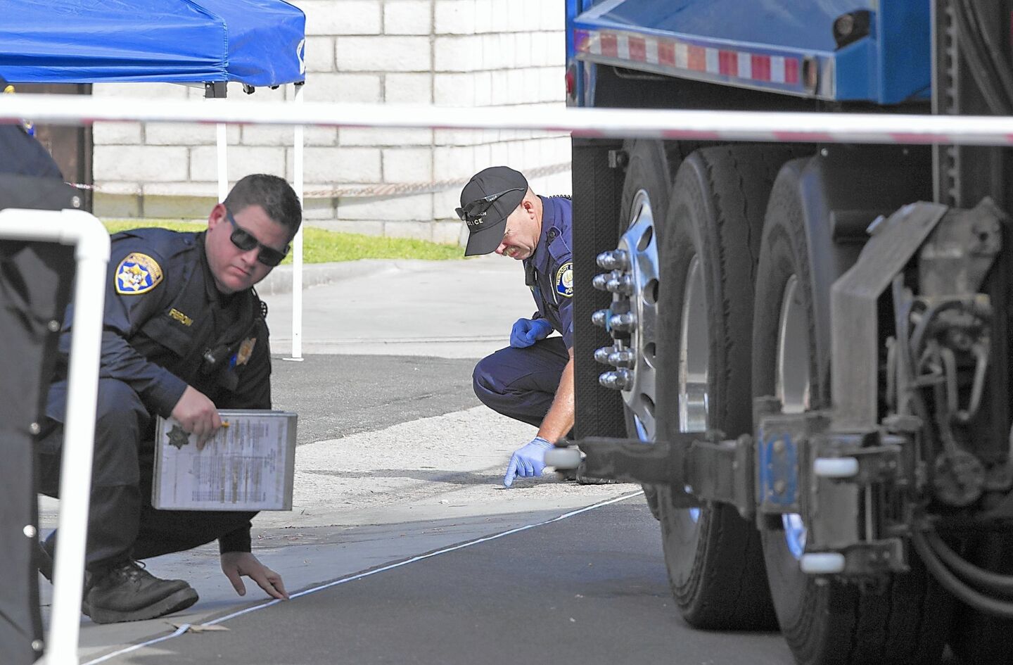 Investigators work the scene where a trash truck hit an 8-year-old boy who was pronounced dead at the scene at the corner of 15th Street and Michael Place in Newport Beach.