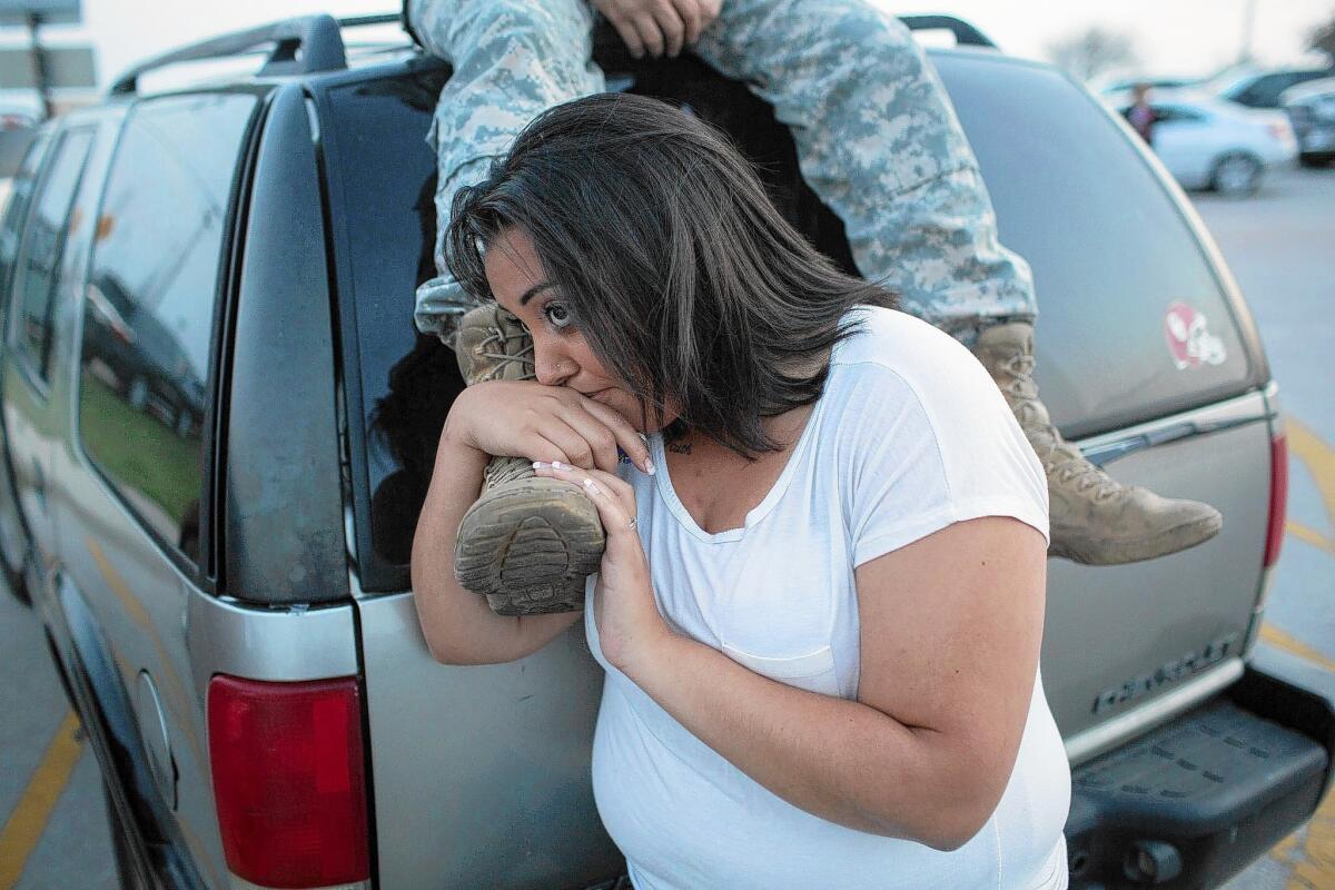 Lucy Hamlin and her husband, Spc. Timothy Hamlin, wait for permission to re-enter the Fort Hood military base, where they live, following a shooting there Wednesday.