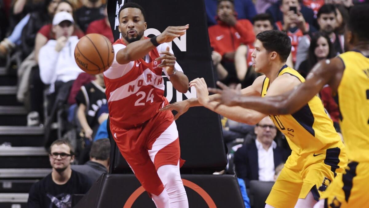 Raptors guard Norman Powell passes the ball after driving against Pacers forward Doug McDermott during the second half Sunday.